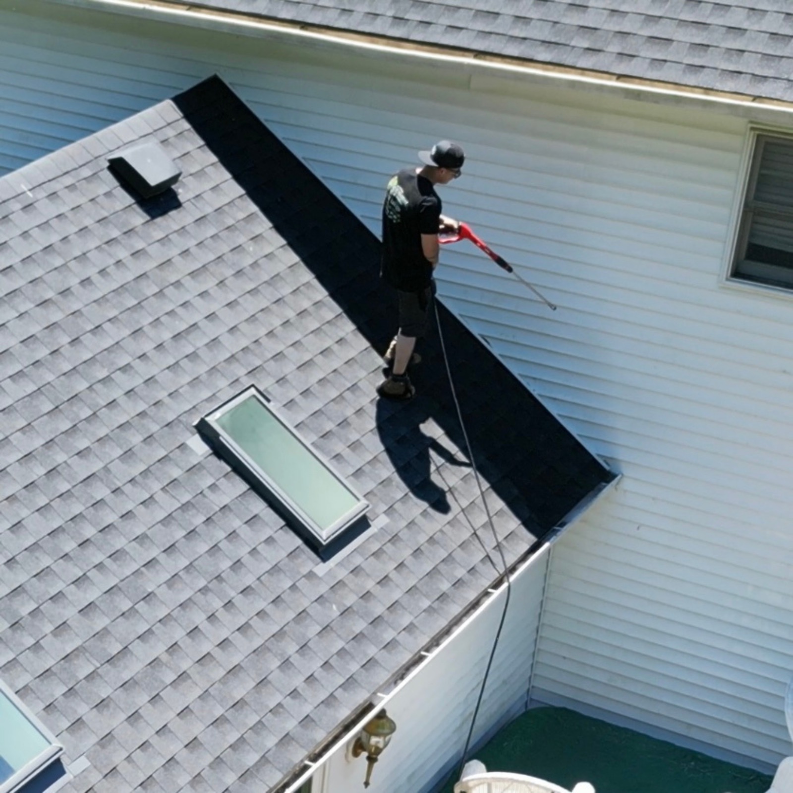 House wash being performed from the roofline